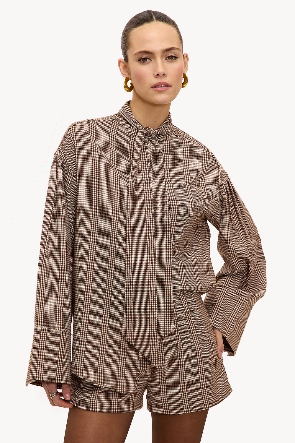 Pantalones cortos marrón claro con estampado de cuadros.