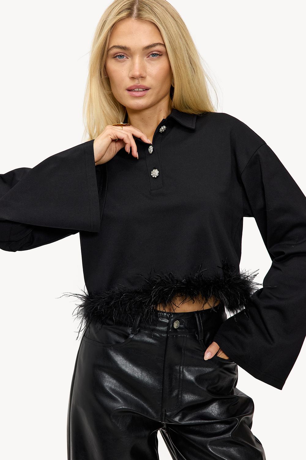 Blusa tipo polo negra con plumas