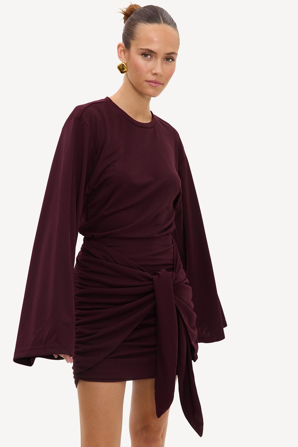 Vestido burdeos con pliegues y detalle de lazo