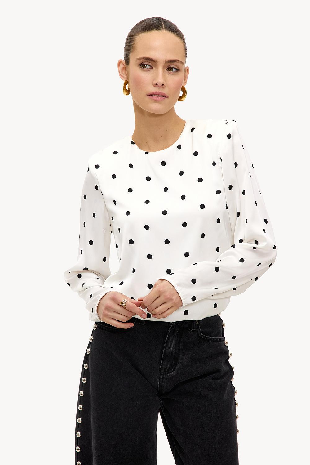 White top with black dots and shoulder pads