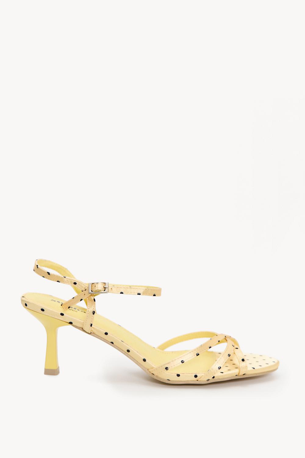 Zapatos de tacón con talón abierto amarillos con lunares.