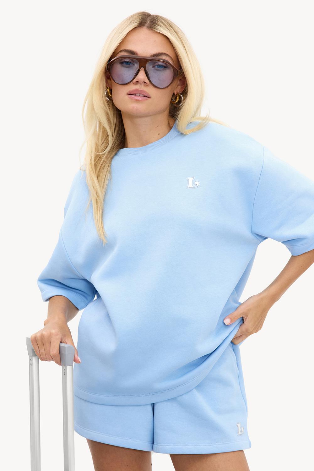 Camiseta azul claro con logotipo plateado