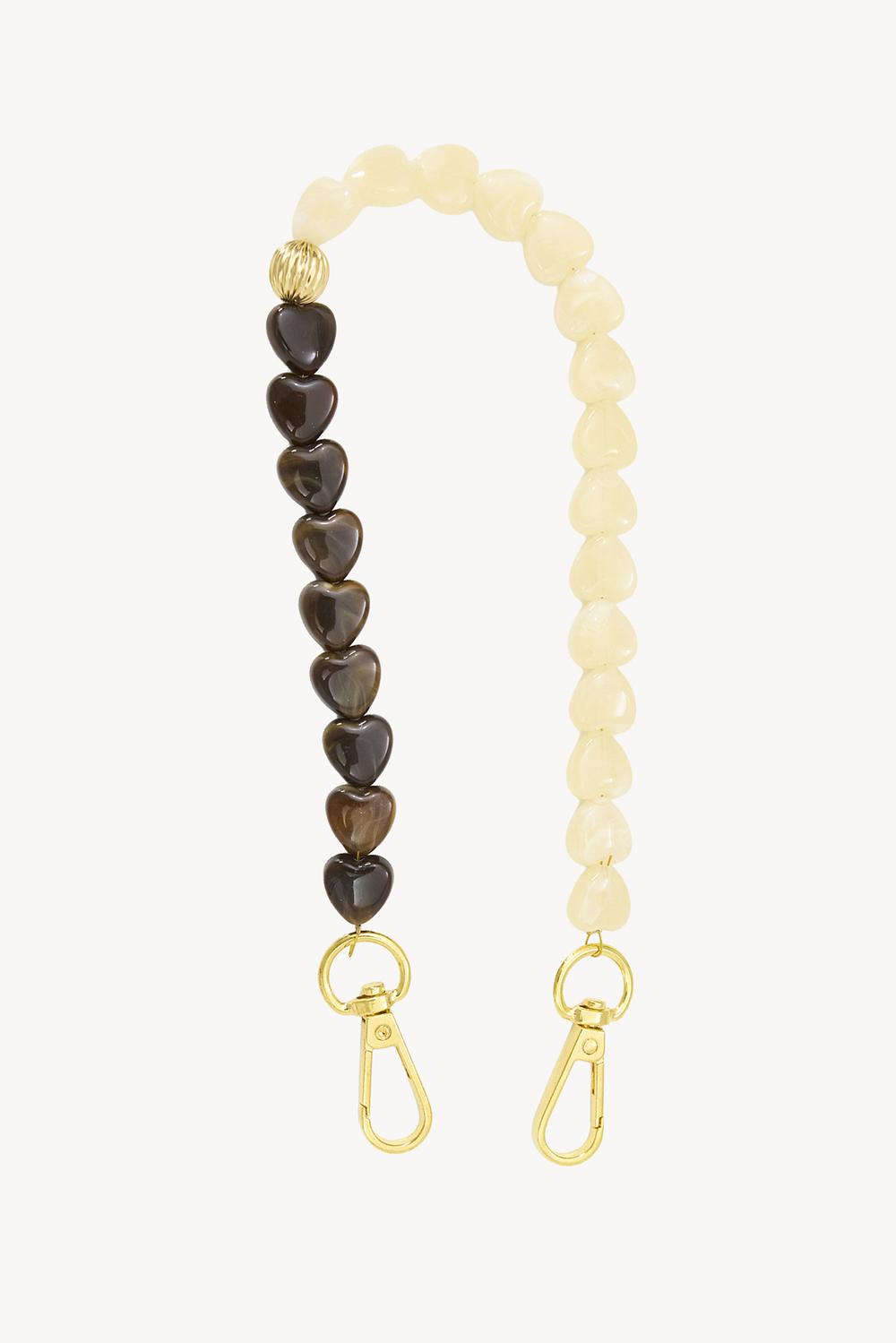 Un cordon de téléphone orné de perles en forme de cœurs marron et blancs