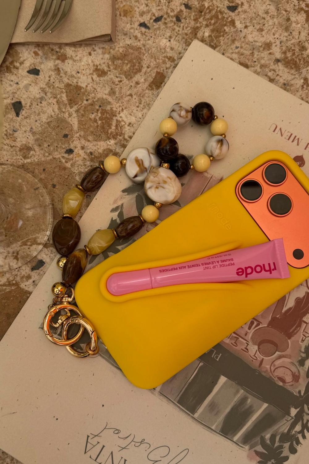 Light yellow phone strap with gold details