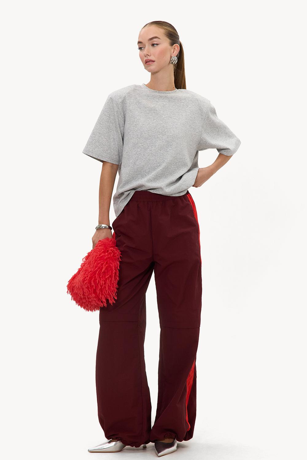 Burgundy parachute track pants with red stripe