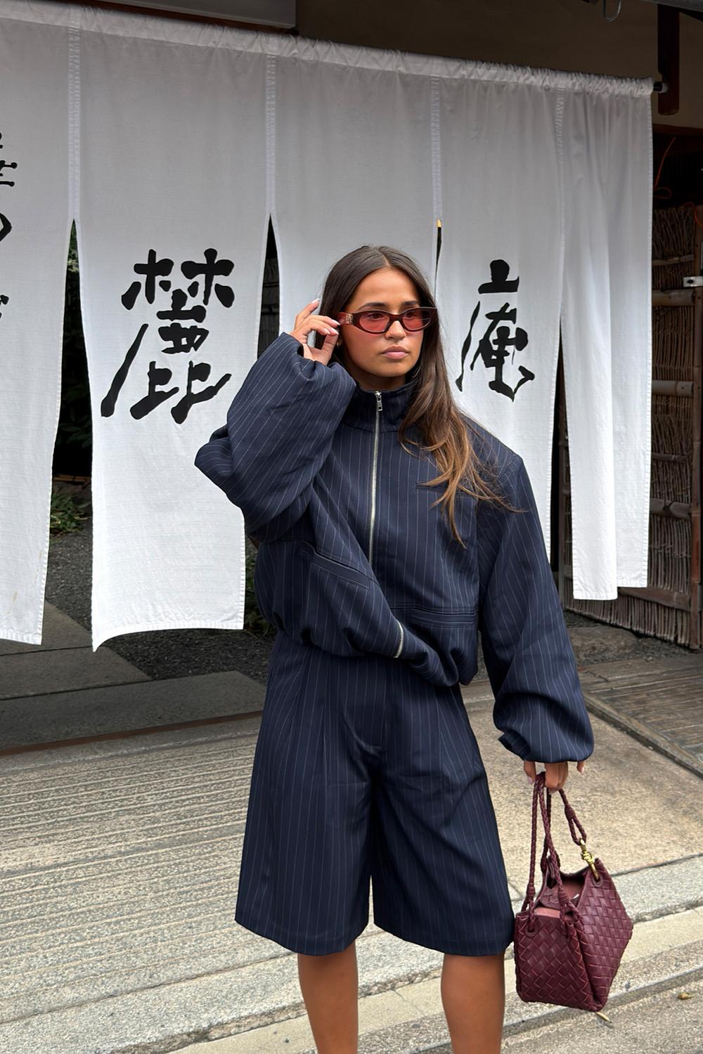 Dark blue jacket with white stripes and shoulder pads
