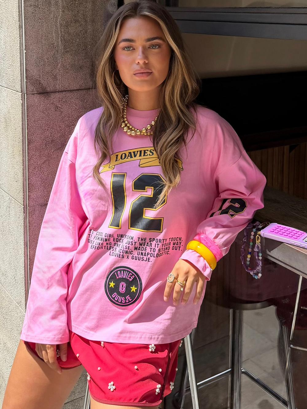 Roze longsleeve top met zwarte en gele tekst